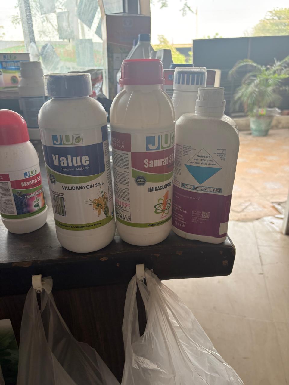 Four white bottles of agricultural chemicals on a table